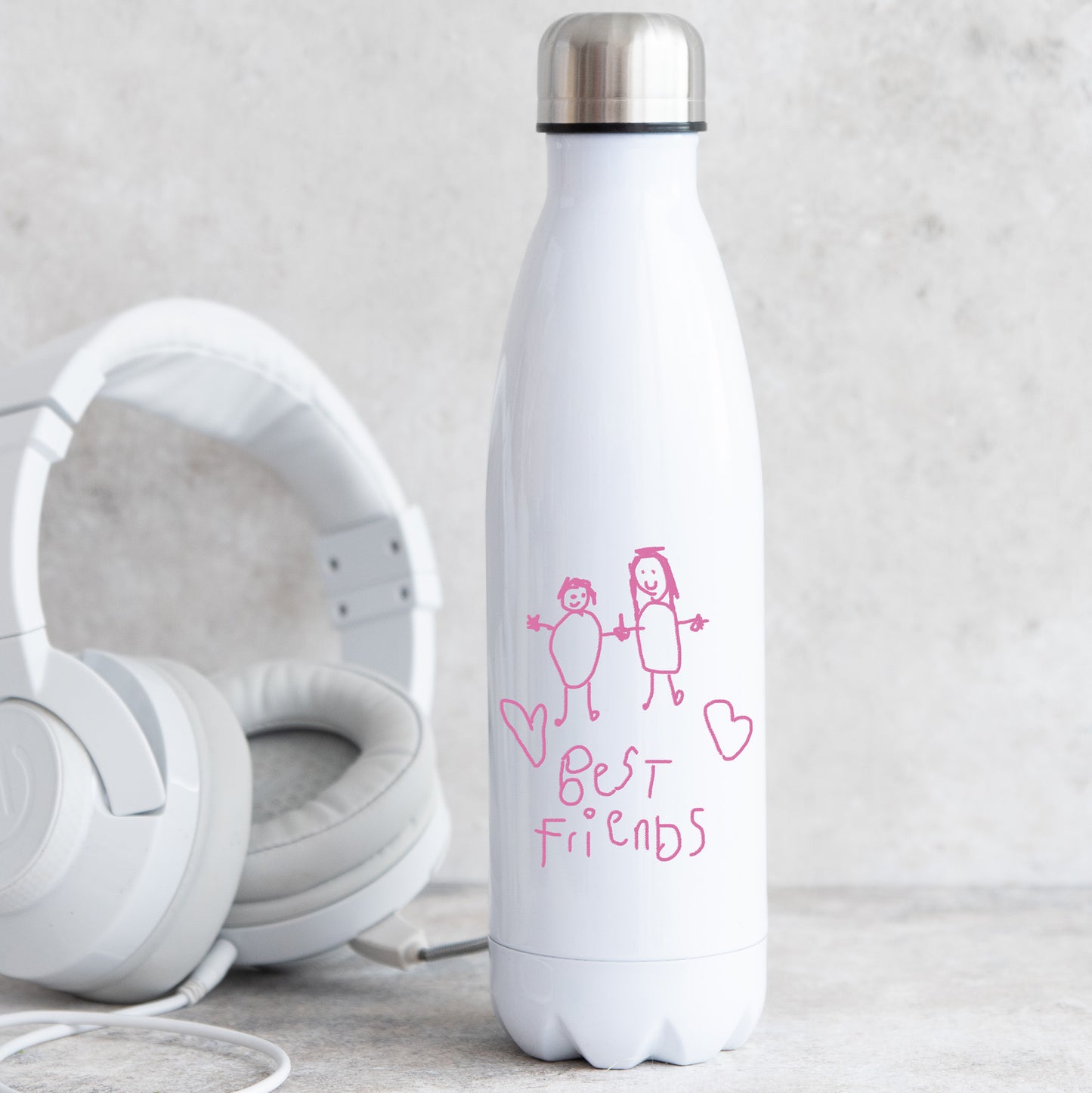 White water bottle with 'Best Friends' design and white headphones on a light gray background | Little Heirloom