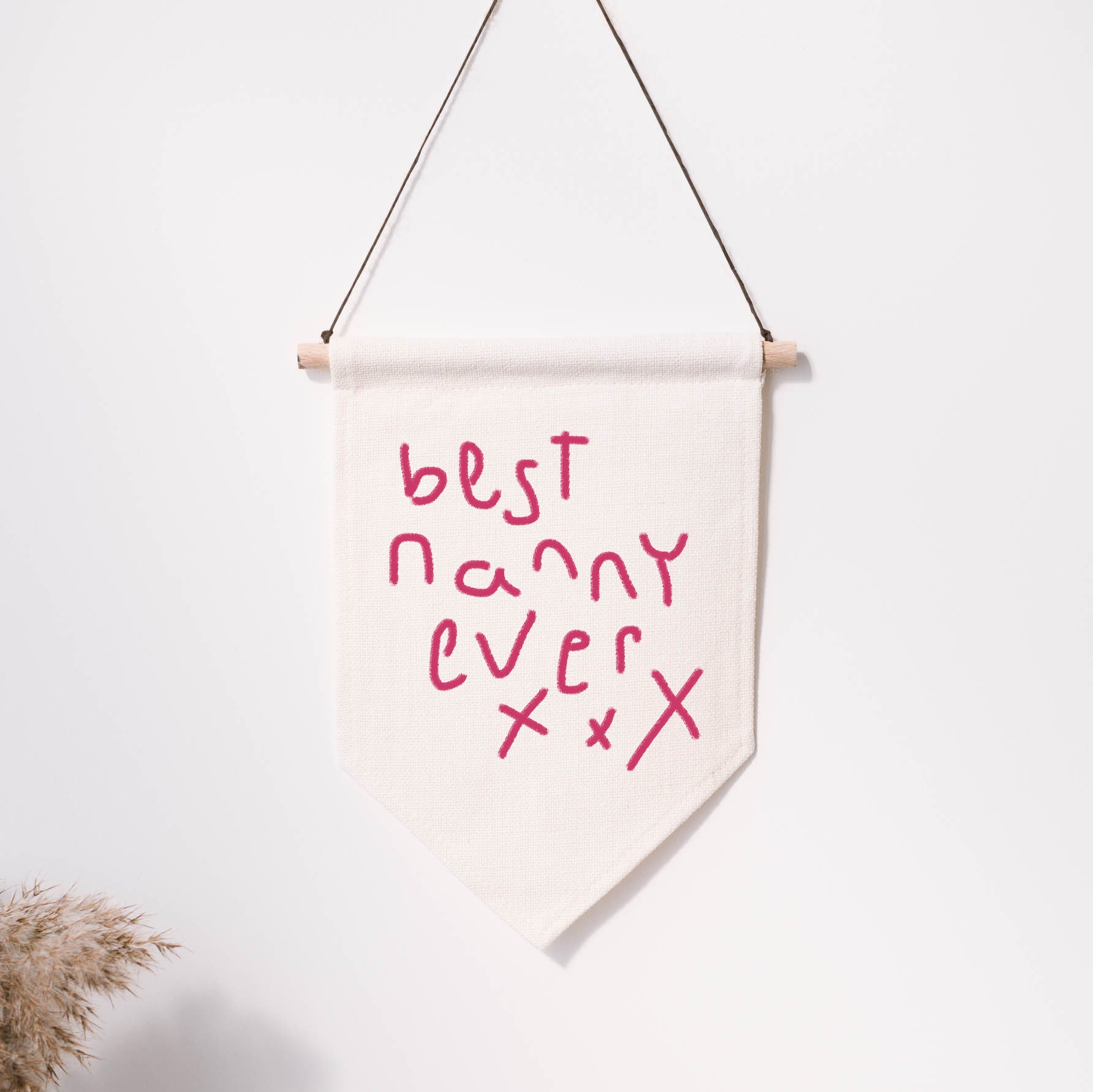 Canvas banner with 'best nanny ever' text on a white wall | Little Heirloom