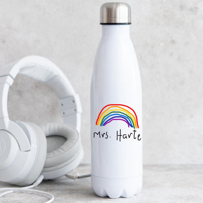 White water bottle with rainbow design and 'Mrs. Harte' text, next to white headphones on a light gray background | Little Heirloom