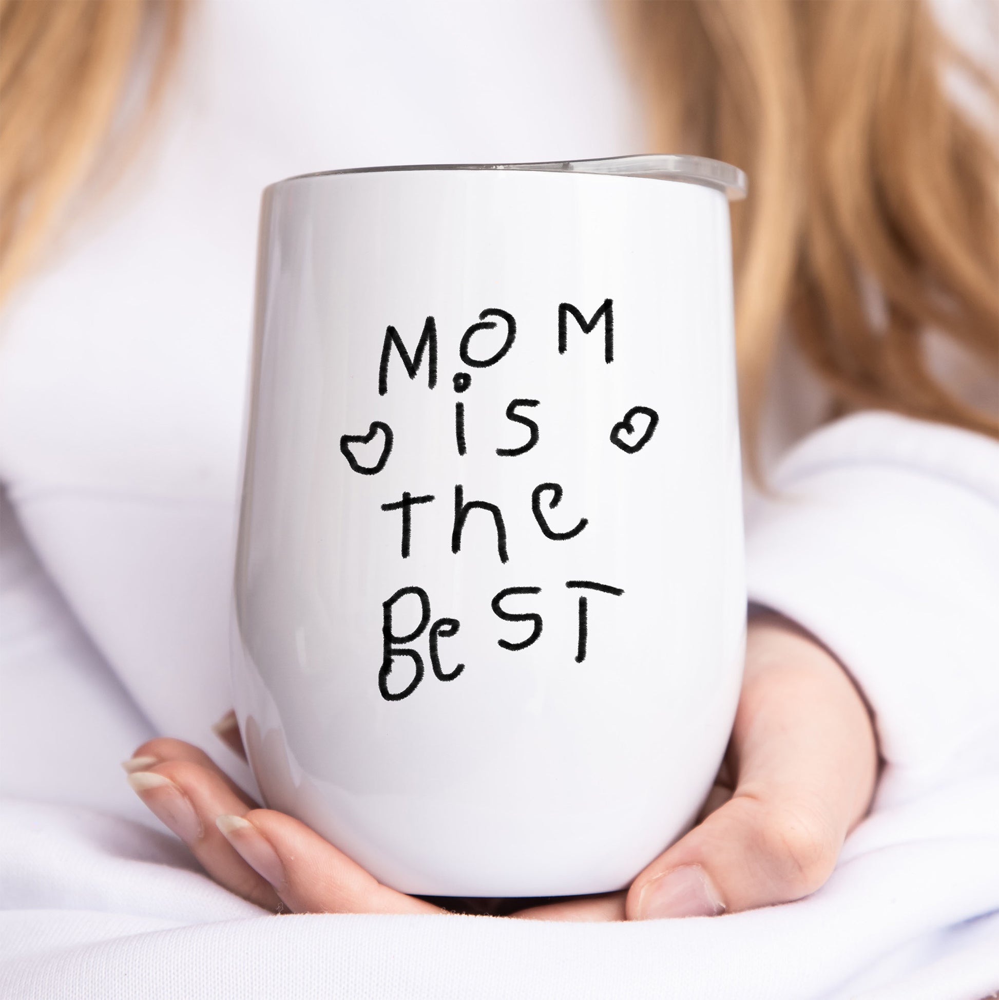 White tumbler with 'Mom is the best' text held by a person | Little Heirloom